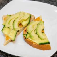 Hummus Toast · With bread, avocado spread & hummus spread topped with cucumber.
