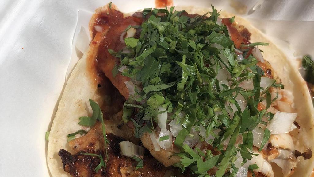 Grilled Fish Taco · Grilled tilapia, griddled corn tortillas, onions, cilantro, salsa casera.