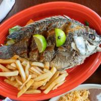 Whole Fried Fish (Pescado Frito) · Dishes are served with rice, beans, salad and french fries.