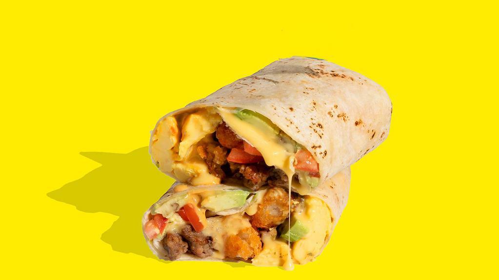 Impossible™ Breakfast Burrito · Wake up and smell the sausage! This burrito has it all! Crumbled Impossible™ Sausage Made From Plants & plant-based egg, crispy tater tots, tomatoes, avocado, plant-based cheese sauce & chipotle crema wrapped in a warm tortilla.