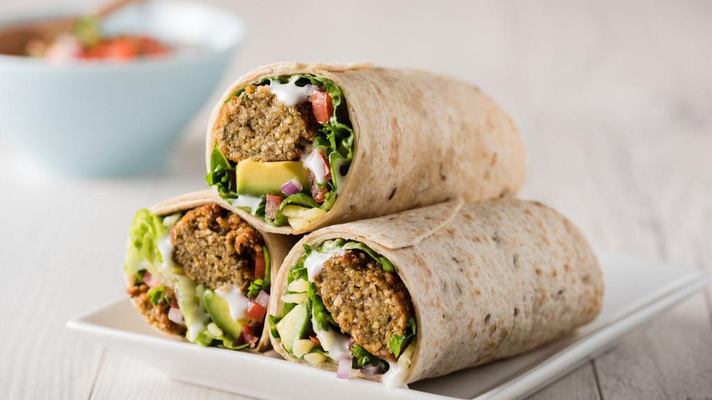 Deluxe Vegan Falafel Wrap · Crispy falafels mixed with lettuce, diced tomatoes, onions, baba ghanoush, hummus, potatoes, parsley, tahini sauce, wrapped in lavash bread.