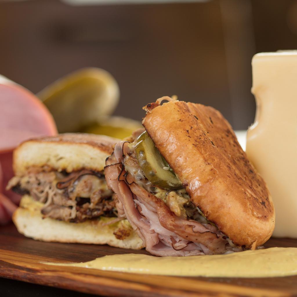 The Cuban · Citrus braised pork, ham, Swiss cheese, pickles, and caramelized onion mustard.  Pressed on sourdough