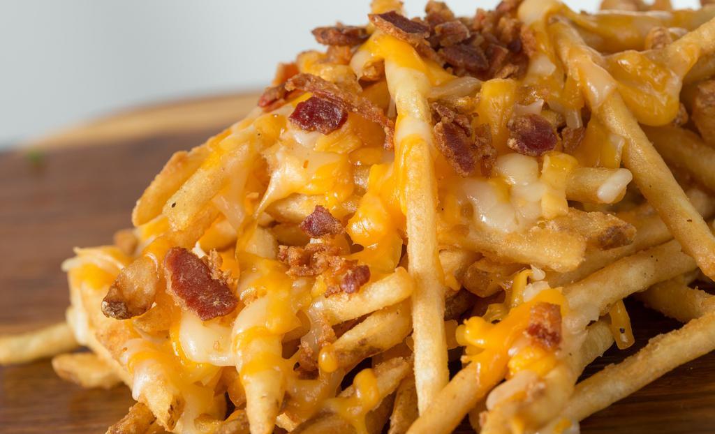 Cheese Fries · A shareable portion of fries, Monterey jack & cheddar cheese, queso, chopped bacon & grilled jalapenos. Served with jalapeno ranch.