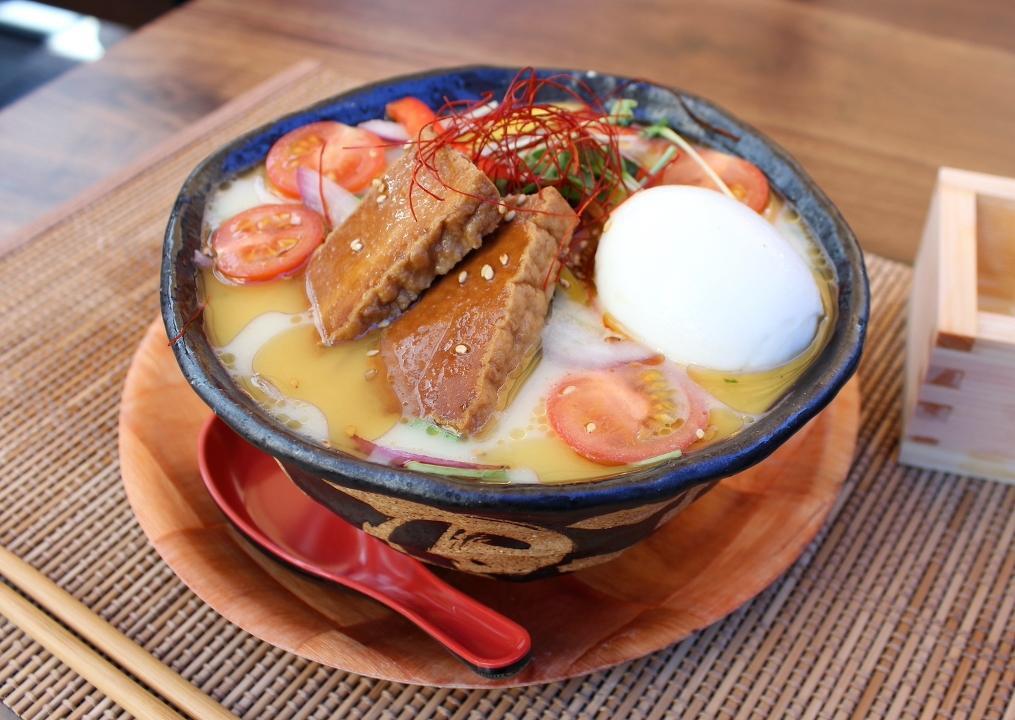 Vegetable Ramen · Creamy vegetable broth with spinach noodles ,Tofu mizuna green, cherry tomato, red and yellow bell pepper, red onion, kaiware sprout, seasoned soft boiled egg. topped with sesame seeds.