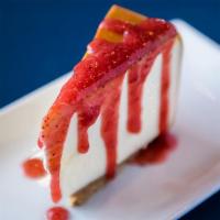 New York Cheesecake · Creamy New York style filling on a buttery, graham cracker crust, strawberry drizzle