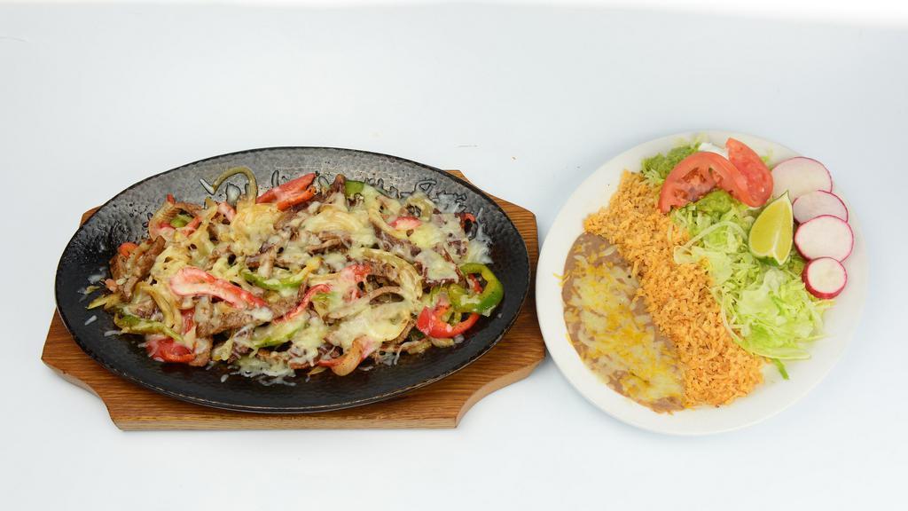 Alambres · Chunks of beef steak, onions, bell pepper, bacon, rice, beans, sour cream, guacamole, salad and tortillas.