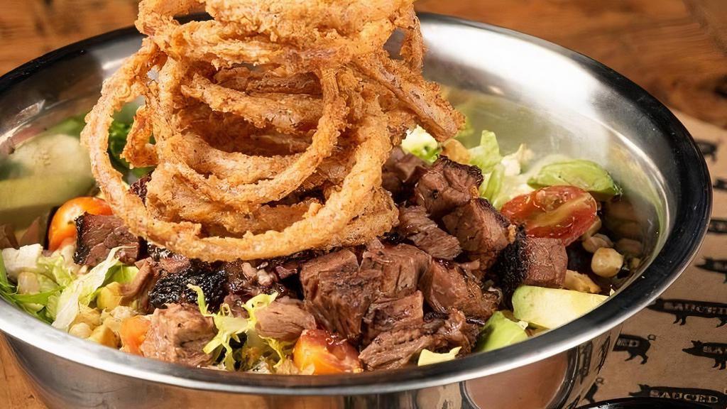 Hella Cali · mixed greens, choice between chopped brisket or pulled pork, . crumbled blue cheese, avocado, roasted corn, grape tomatoes and fried onion . strings – served with bbq ranch.  (Chopped Brisket Pictured)