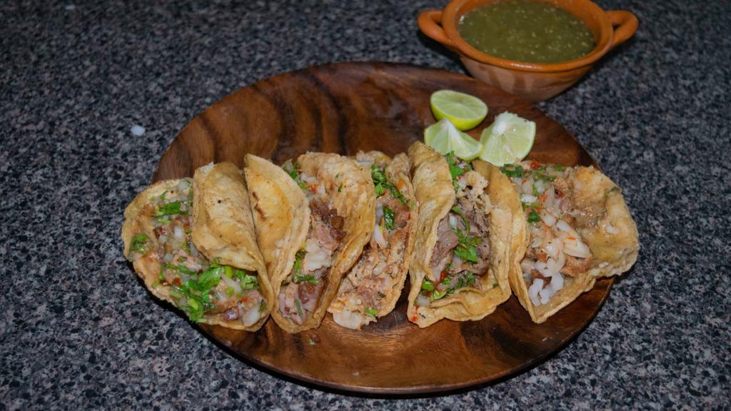 Tripas (Beef Tripes) Taco · Mexican-style Taco prepared with Grilled Beef Tripes, and topped with cilantro, diced onions, and hot sauce.