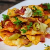 Super Nachos · Crispy nachos topped with melted cheese, and served with a side of sour cream, salsa, and gu...