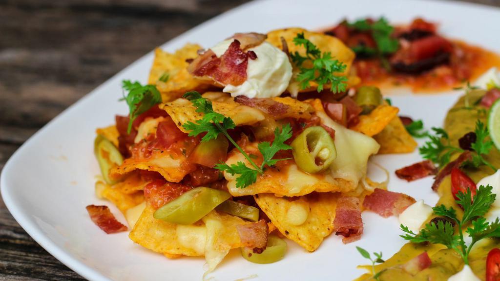 Super Nachos · Crispy nachos topped with melted cheese, and served with a side of sour cream, salsa, and guacamole.