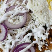 Chilaquiles Rojas Con Huevos Y Carne · Served with rice, beans, and potatoes.