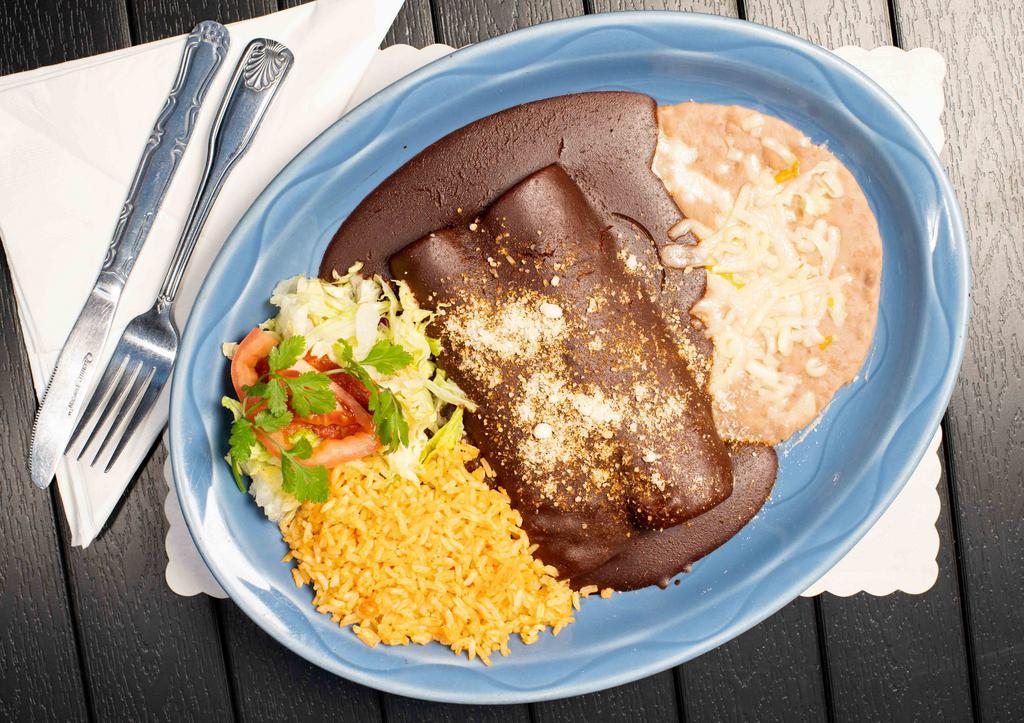 17. Enchiladas en Mole Sauce · Two shredded chicken, ground beef or cheese enchiladas smothered in a rich dark chocolate sauce made of ground chilis, seeds, nuts and spices topped With a dash of Parmesan cheese.