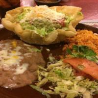 9. Fiesta Tostada · Crispy flour tortilla shell filled with shredded chicken or ground beef and beans, lettuce, ...