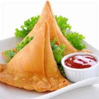 Veggie Samosas · Hand crafted Indian pastry filled with potatoes, peas and ginger garlic. Served with cilantr...