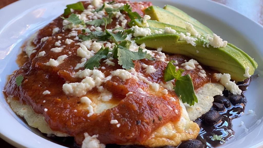 HUEVOS RANCHEROS · Two over medium fried eggs, served on hot handmade tortillas, homemade black beans, mild salsa, topped with queso fresco and avocado slices.