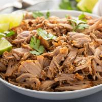 Carnitas · A delightful entrée of marinated Pork cut into cubes. Served with a side of refried  beans a...
