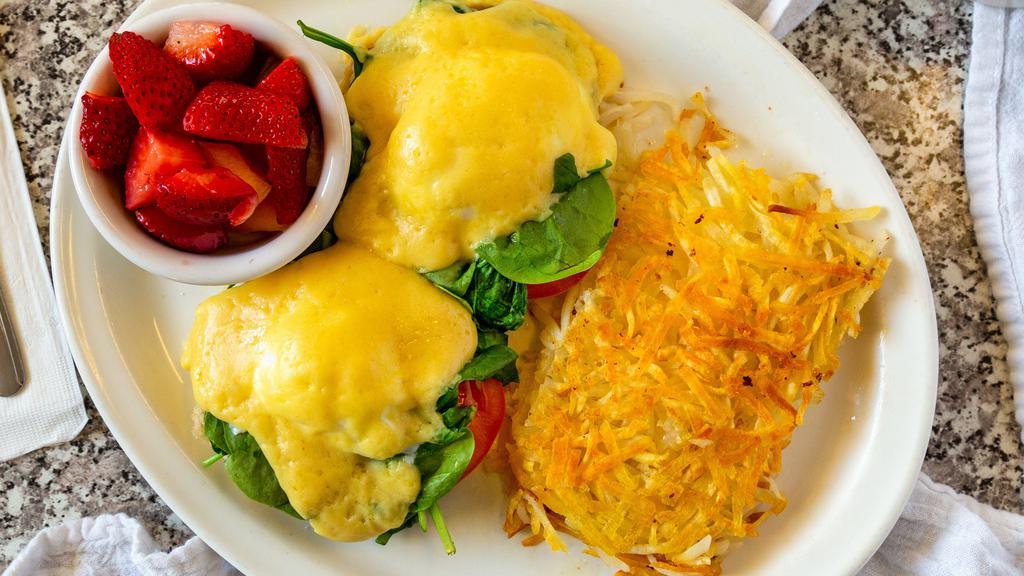 Eggs Florentine · Grilled English muffin halves topped with sliced tomato, fresh spinach, poached eggs, and topped with hollandaise sauce.