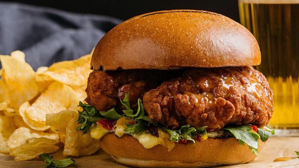 Classic Crispy Tender Sandwich · two crispy jumbo, hand tossed buttermilk-battered, antibiotic & hormone free, never frozen chicken tenders served on a toasted bun with lettuce, orange basil aioli, dijon honey sauce, chow chow relish. served with chips