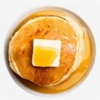 Pancakes · Three fluffy pancakes with syrup and butter on the side.
