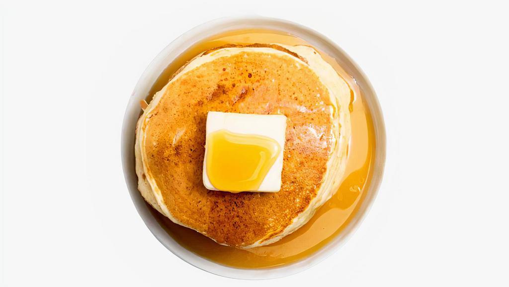 Pancakes · Three fluffy pancakes with syrup and butter on the side.