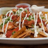 Original Nacho Chips · Corn chips, meat, refried beans, onions, cilantro, sour cream, cheese, and salsa.