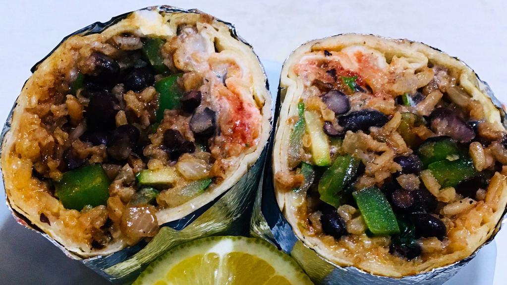 Super Veggie Burrito · Roasted Zucchini, bell peppers, cabbage, onions, cilantro, black beans, rice, sour cream, cheese, and salsa.