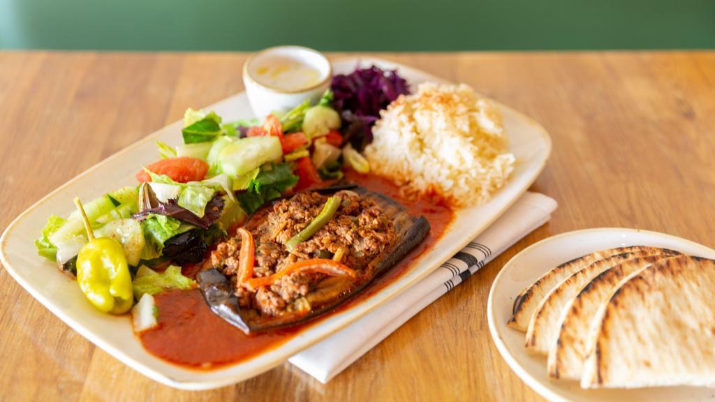 Stuffed Eggplant (Meat) · Baked eggplant stuffed with ground beef, tomato, onion, garlic, bell peppers with tomato sauce. Served with rice, salad and pita bread.
