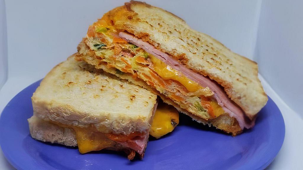 Korean Omelette Toast · buttered toast with an eggs, shredded cabbage, carrots, and green onions folded into an omelette, ham and cheese.  Served with a side of spicy Korean ketchup.