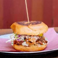 Pulled Pork Sandwich · Topped with Slaw, sauce, and pickles. Dressed with our Mustard & Vinegar sauce.