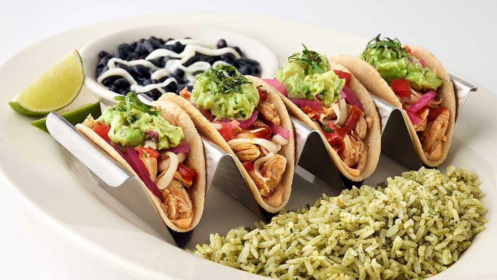 Baja Chicken Tacos · Soft Corn Tortillas Filled with Mildly Spicy Chicken, Cheese, Tomato, Avocado, Onion, Chipotle and Cilantro. Served with Rice and Beans