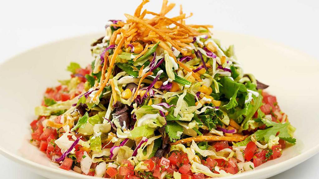 Mexican Tortilla Salad · Crispy Corn Tortilla Topped with Grilled Chicken Breast and Black Beans with Mixed Greens, Fresh Corn, Green Onion and Cilantro. All Tossed in Our SkinnyLicious® Vinaigrette and Garnished with a little Avocado Cream Sauce, Salsa and Sour Cream