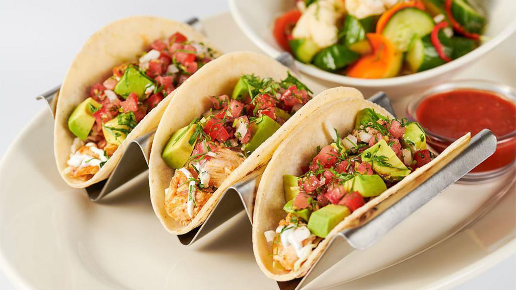 Skinnylicious® Chicken Soft Tacos · Three Soft Corn Tortillas Filled with Spicy Chicken, Avocado, Tomato, Onions, Cilantro and Crema. Served with Escabeche Vegetable Salad
