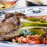 Carne Asada Plate · Grilled steak garnished with green onions and bell peppers, served with rice, refried beans,...