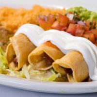 Flautas · Two deep-fried rolled-over tortillas with choice of meat topped with ranchera sauce, sour cr...