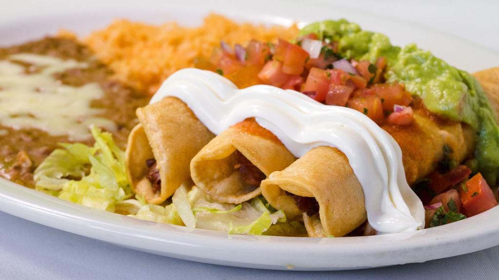 Flautas · Two deep-fried rolled-over tortillas with choice of meat topped with ranchera sauce, sour cream, pico de gallo, and guacamole, served with rice and beans.