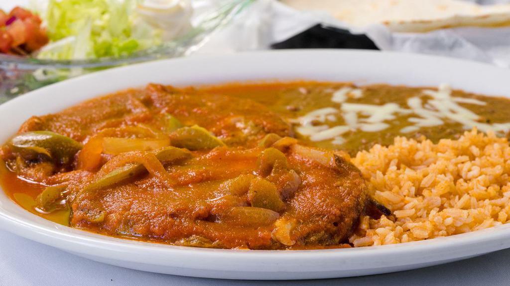 Chiles Rellenos · Two butter and fried poblano peppers stuffed with cheese and topped with ranchera sauce, served with rice, refried beans and tortillas.
