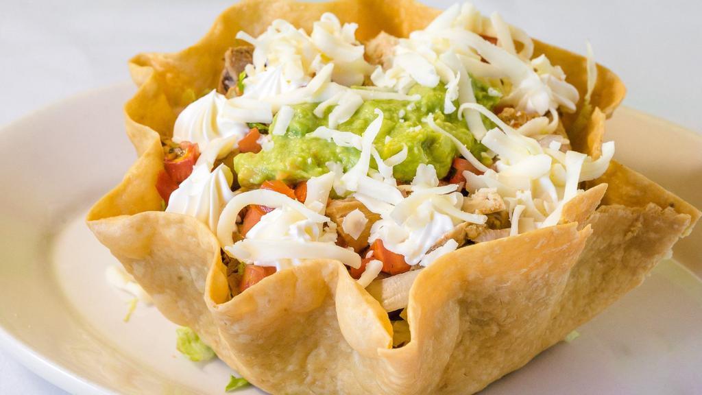 Taco Salad · A flour shell filled with lettuce, whole, pinto beans, pico de gallo, sour cream, cheese and guacamole. Add shrimp, fish, tongue for additional cost.