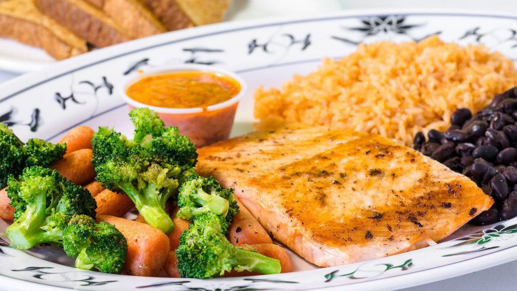 Grilled Salmon · A plate with grilled salmon fillet, served with rice, black beans, veggies and toast.