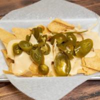 Nacho · Our homemade corn tortilla chips topped with a cheddar cheese sauce.