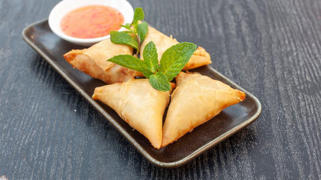 Samosas · Vegetarian. Triangular shaped hand wrapped and filled with curried potatoes, red onions, peas and carrots. Fried and served with special sauce.