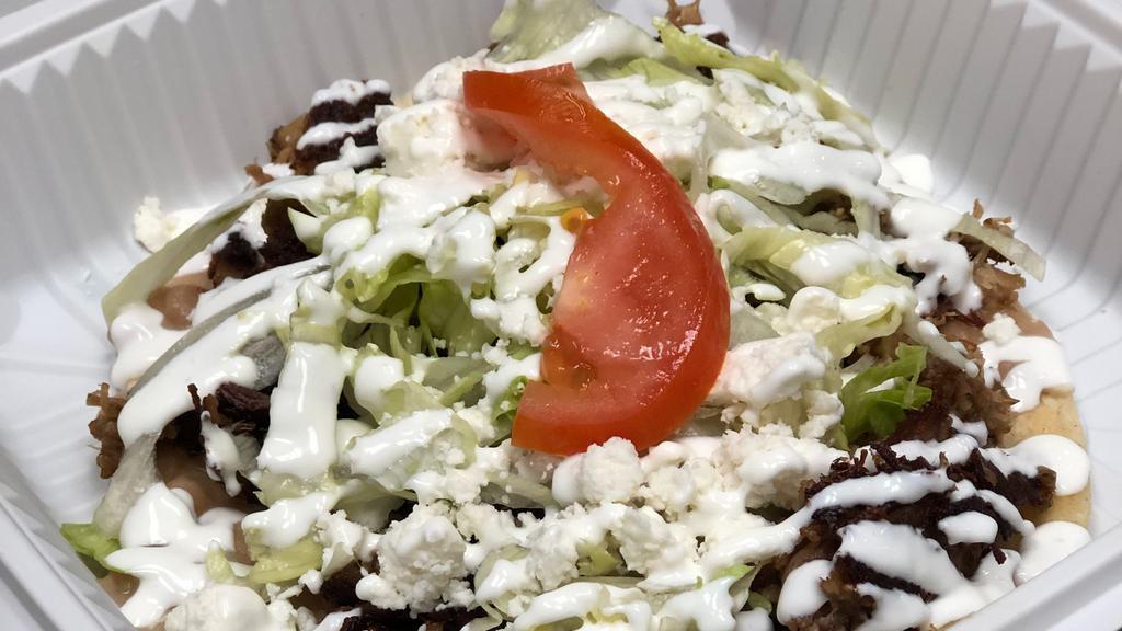Huarache Taco(homemade tortillas) · Oversized handmade corn tortilla layered with refried beans, choice of meat topped with lettuce, sour cream, and queso fresco