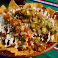 Super Nachos · Homemade tortilla chips, choice of meat, beans, cheese, guacamole, sour cream, jalapeños, an...