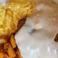 Country Fried Steak · Country fried steak smothered with country gravy, served with two eggs any style, country po...