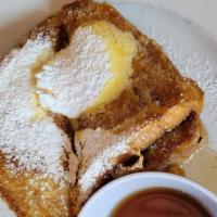 Plain Stack · Four slices of French toast topped with butter and warm maple syrup on the side.