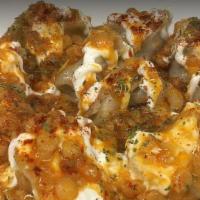 Mantoo Veggie · Steamed dumplings stuffed with mushrooms, cabbage, onions and spices, topped with garlic yog...