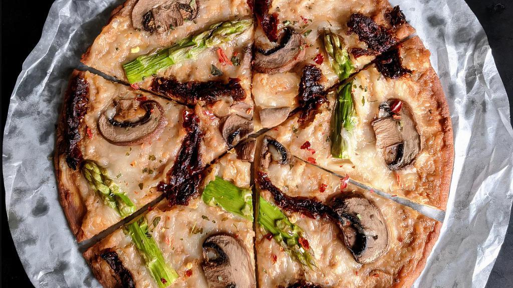 Creamy Mushroom Pizza · Creamy almond sauce, shredded mozzarella, mushrooms, asparagus and sun-dried tomatoes, garnished with dried fenugreek leaves. 8” keto crust pizza. 
Grain free. Gluten free
470 cals, 36g fat, 26g protein, 9g net carb.