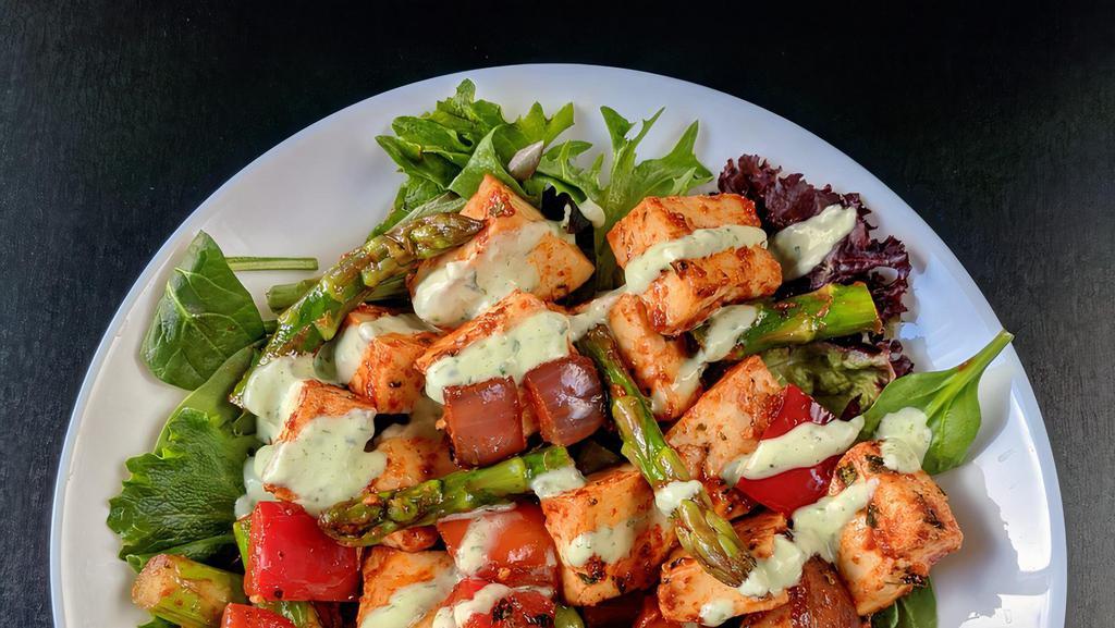 Paneer Tikka Salad · Spiced cottage cheese cubes (paneer) cooked with onions and peppers in a bed of salad greens served with avocado slices and mint crema