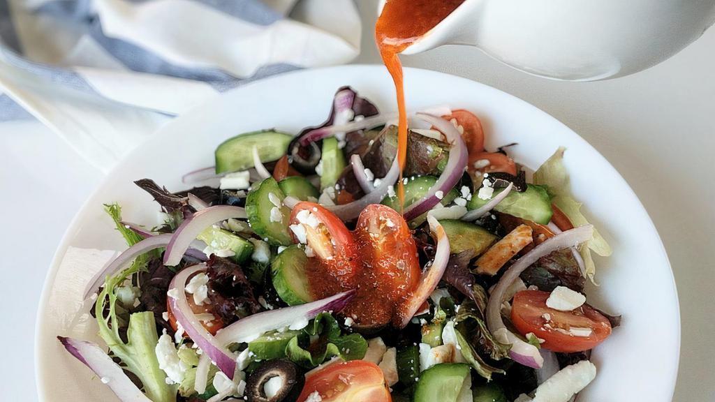 Greek Salad · A summery Mediterranean salad to enjoy all year long - cucumber, olives, feta, tomatoes, salad greens, and red onions, with a sun-dried tomato vinaigrette.
