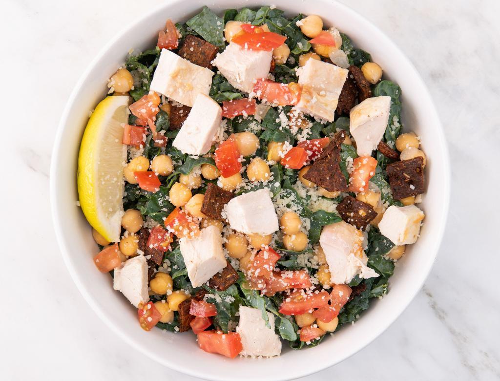 Thrive Kale Caesar Salad · Shredded kale, parmesan cheese, chickpeas, diced tomatoes, vegan caesar dressing, lemon wedge. Served with your choice of chicken or roasted sesame tofu.