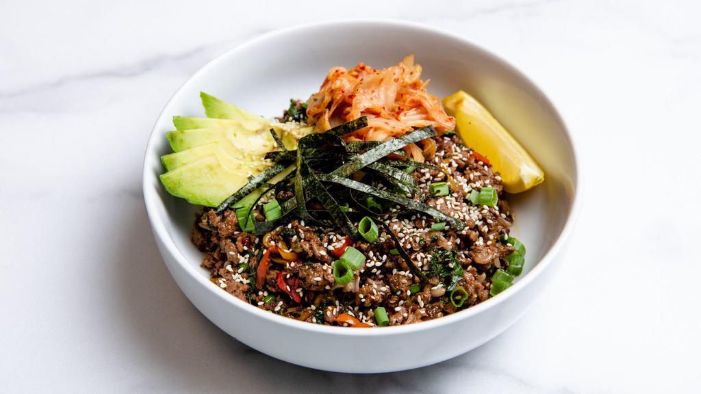 Thrive Avocado Bulgogi Bowl · Impossible beef with sliced avocado, kimchi, charred peppers, citrus-marinated kale, caramelized onions, green onions, seasoned seaweed, sesame seeds, and our ginger garlic soy sauce. Served with a lemon wedge and a base of your choice. Gluten-free and vegan.